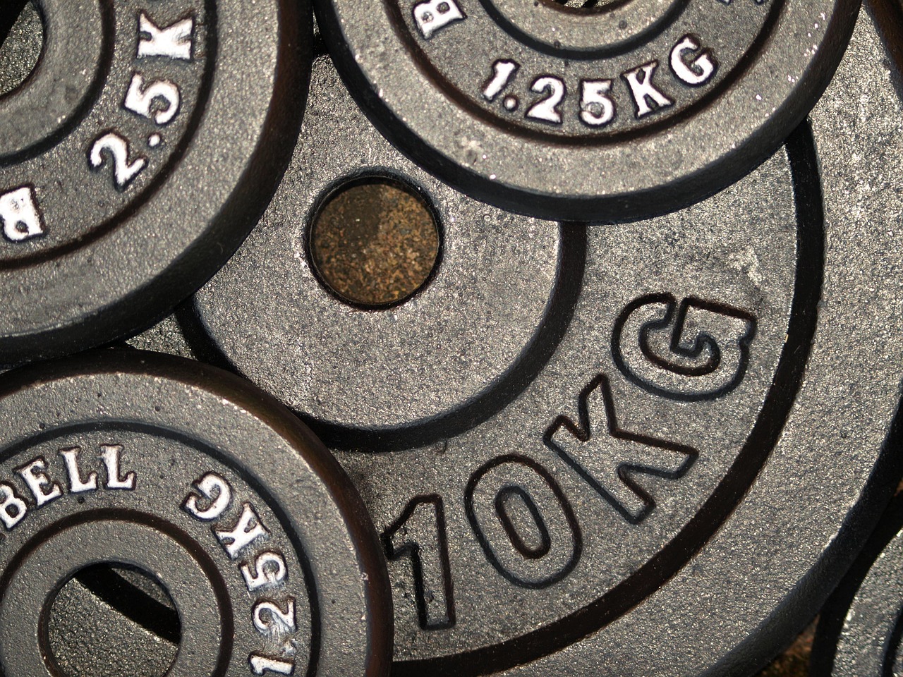 Ten kilogram plates stacked on a gym floor.